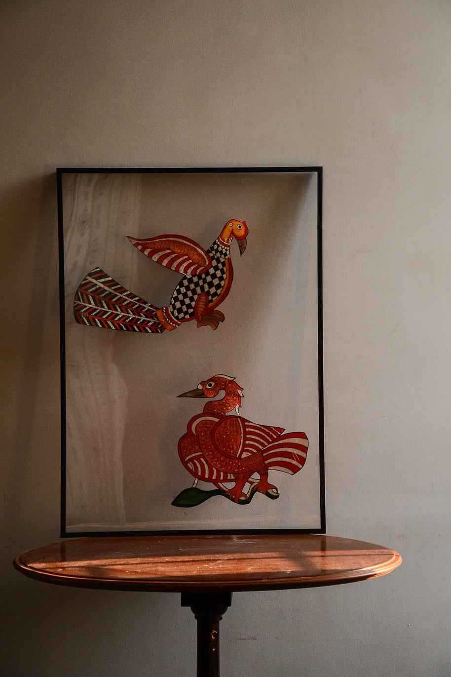Tholu Bommalata leather puppets - checkered bird with fanned chevron tail above a Hamsa on a branch, shown mounted for display