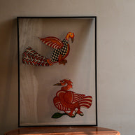 Tholu Bommalata leather puppets - checkered bird with fanned chevron tail above a Hamsa on a branch, shown mounted for display