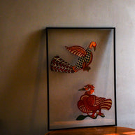 Tholu Bommalata puppets - Hamsa and checkered bird in warm evening light, shown mounted for display on a wooden table