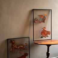 Tholu Bommalata leather puppet pairs - tiger and leopard leaning against the wall, Hamsa and checkered bird on a pedestal table