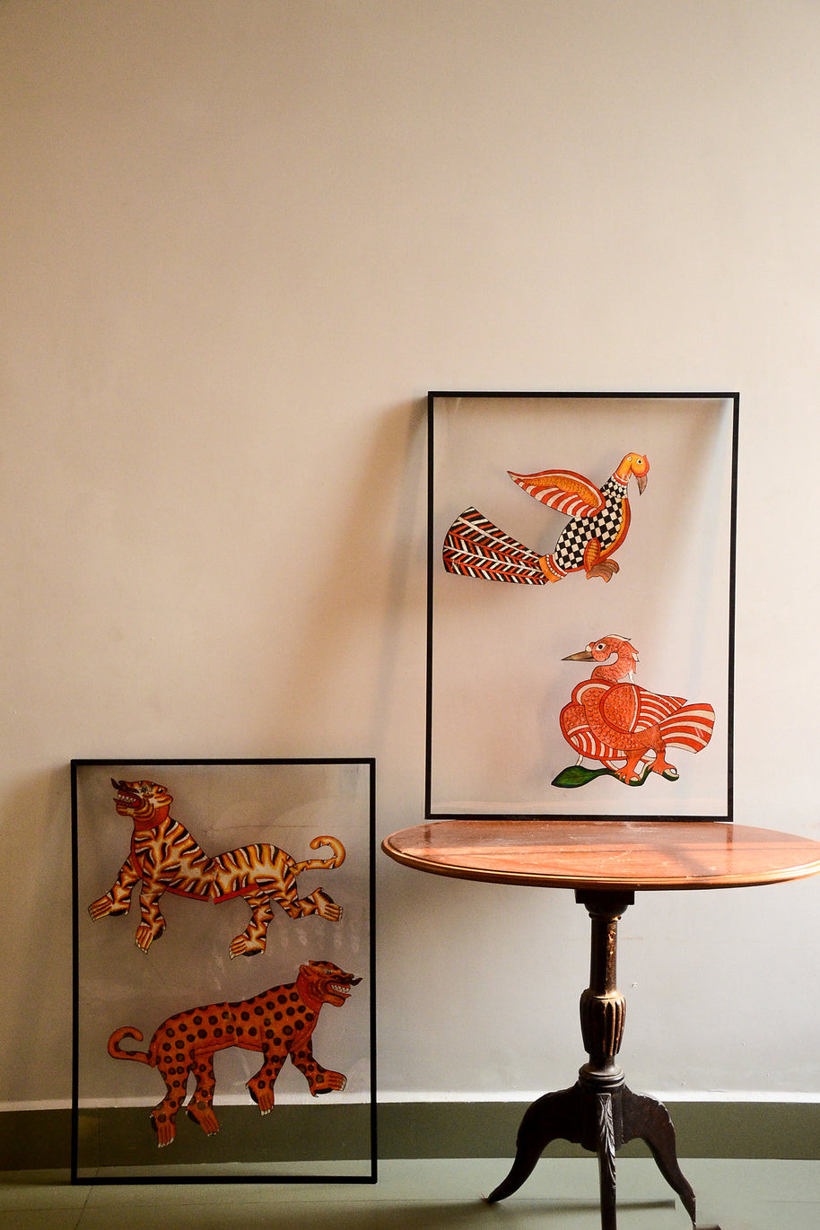 Tholu Bommalata puppets - tiger and leopard pair and Hamsa and checkered bird pair, shown mounted for display against a cream wall