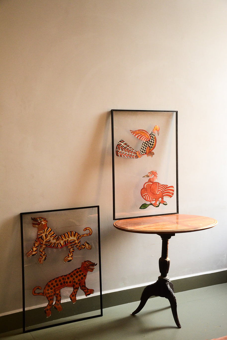 Tholu Bommalata leather puppets - two hand-painted pairs, animals and birds, shown mounted for display in a softly lit room