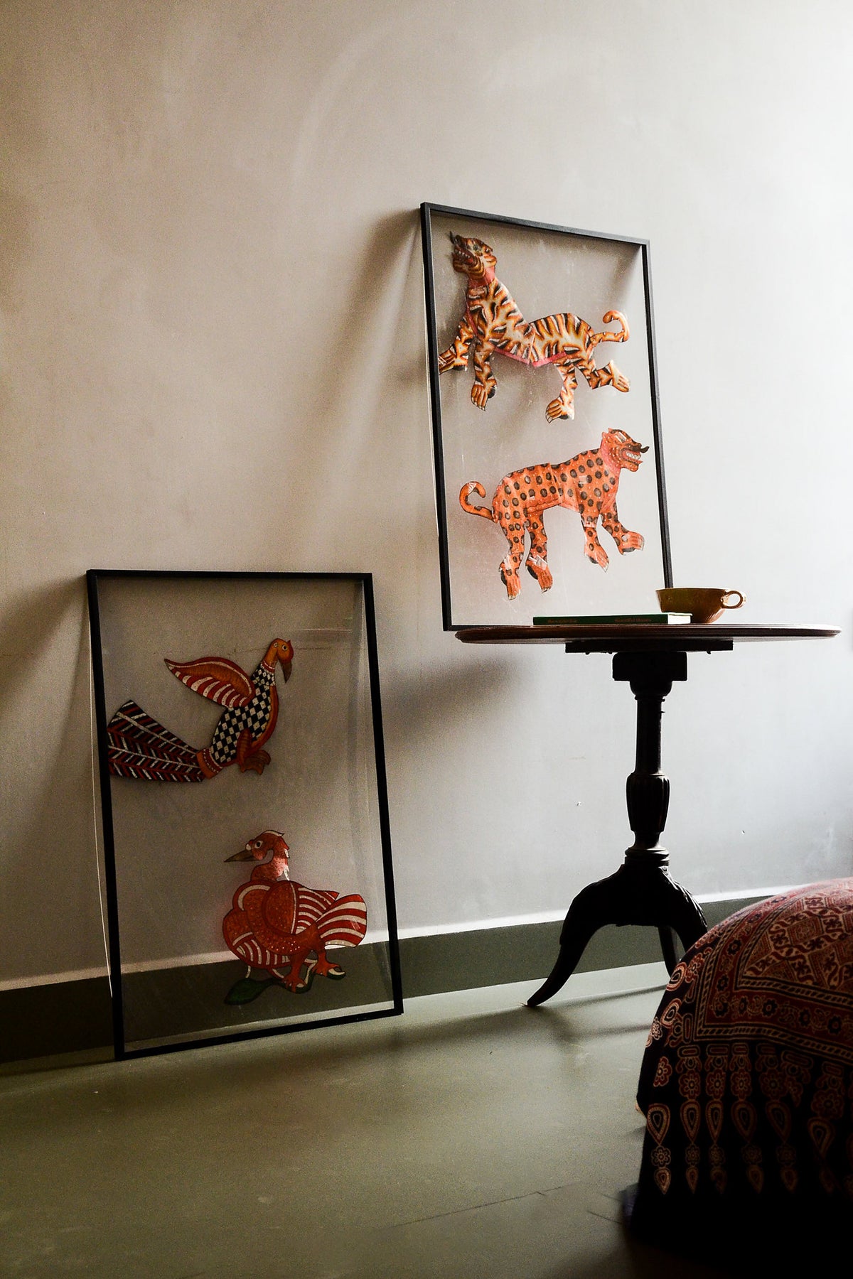 Tholu Bommalata puppets styled in a living space - Hamsa and checkered bird beside a tiger and leopard pair on a pedestal table