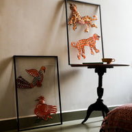 Tholu Bommalata puppets styled in a living space - Hamsa and checkered bird beside a tiger and leopard pair on a pedestal table