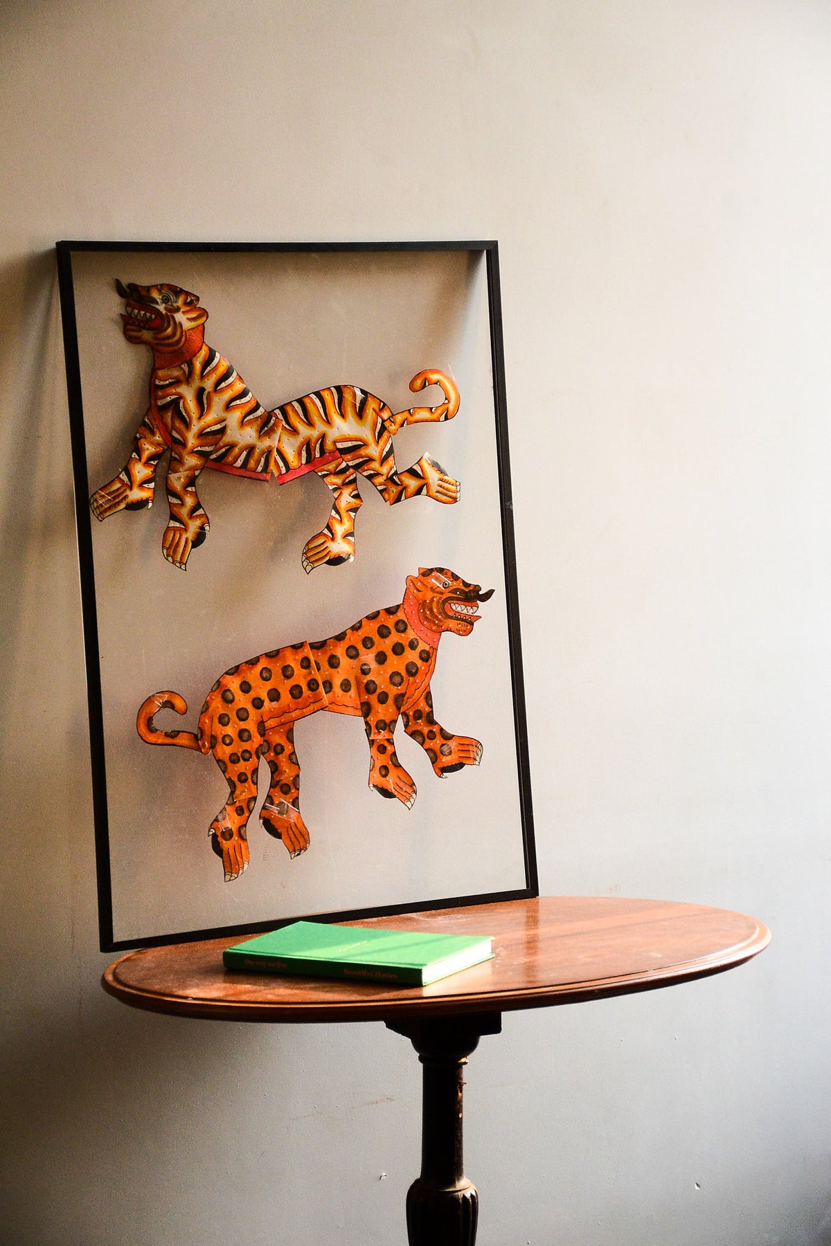 Tholu Bommalata puppets - striped tiger and spotted leopard in saffron, orange and black, shown mounted for display